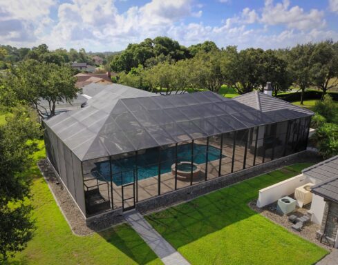 Custom aluminum pool cage built over paver deck and kidney-shaped pool in Florida